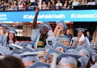 A crowd of graduates wearing academic regalia celebrate